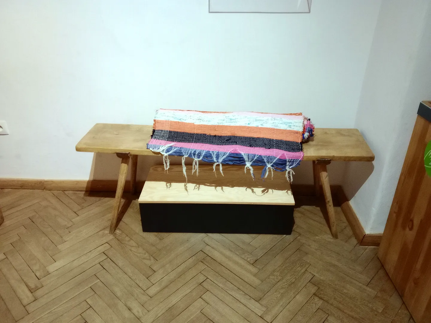 A traditional polish rustic wooden bench with handwoven rug